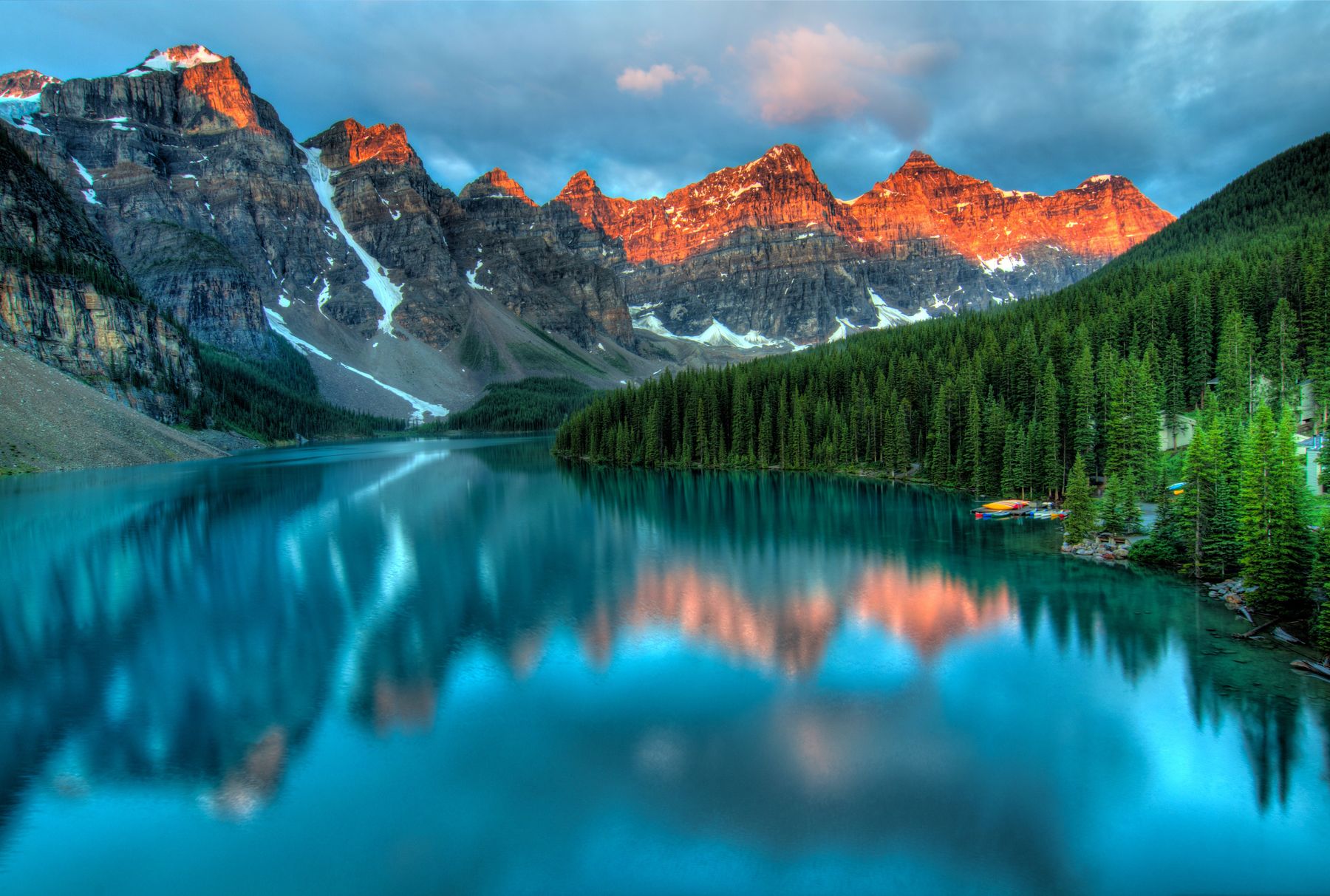 Stillgelegter Bergsee unter einem steilen Grat in den österreichischen Alpen am frühen Morgen